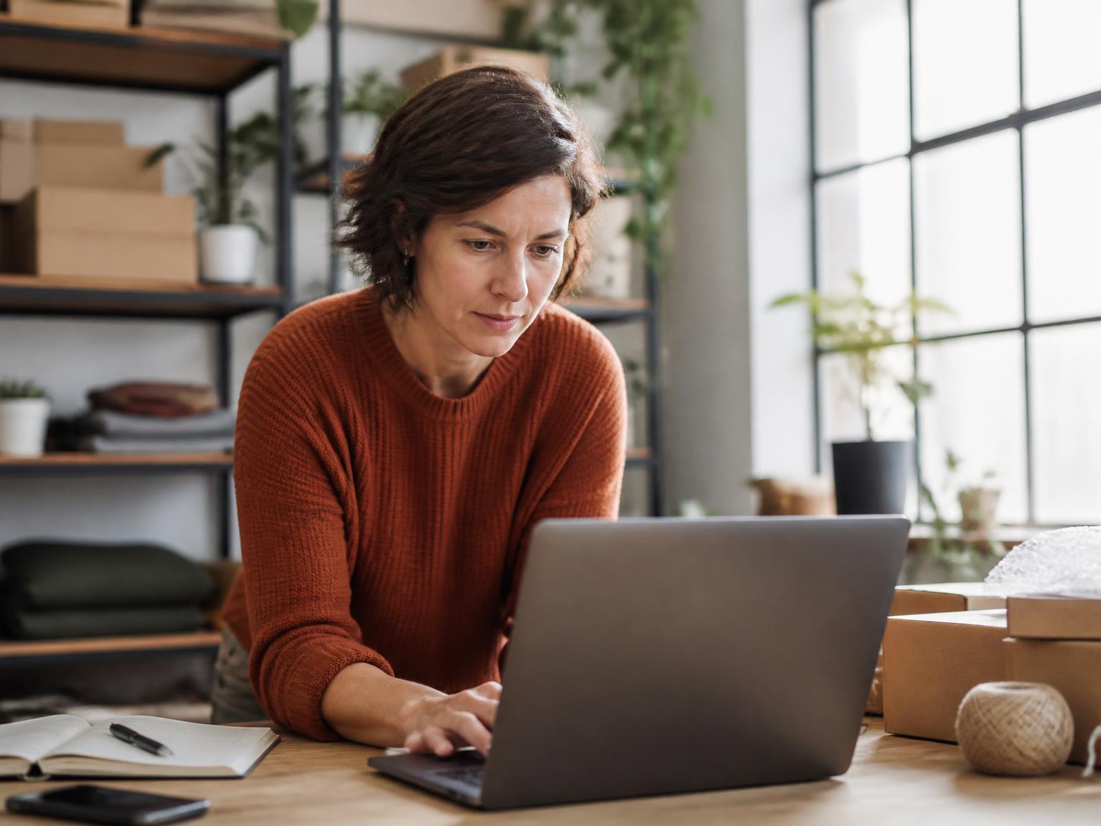 Propriétaire de PME consultant son portail client sur un ordinateur portable